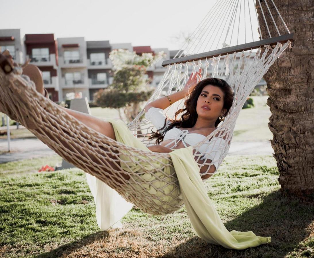 Sunrise Crystal Bay Resort -Grand Select (Adults Only) Hurghada Exterior photo A woman relaxing in a hammock